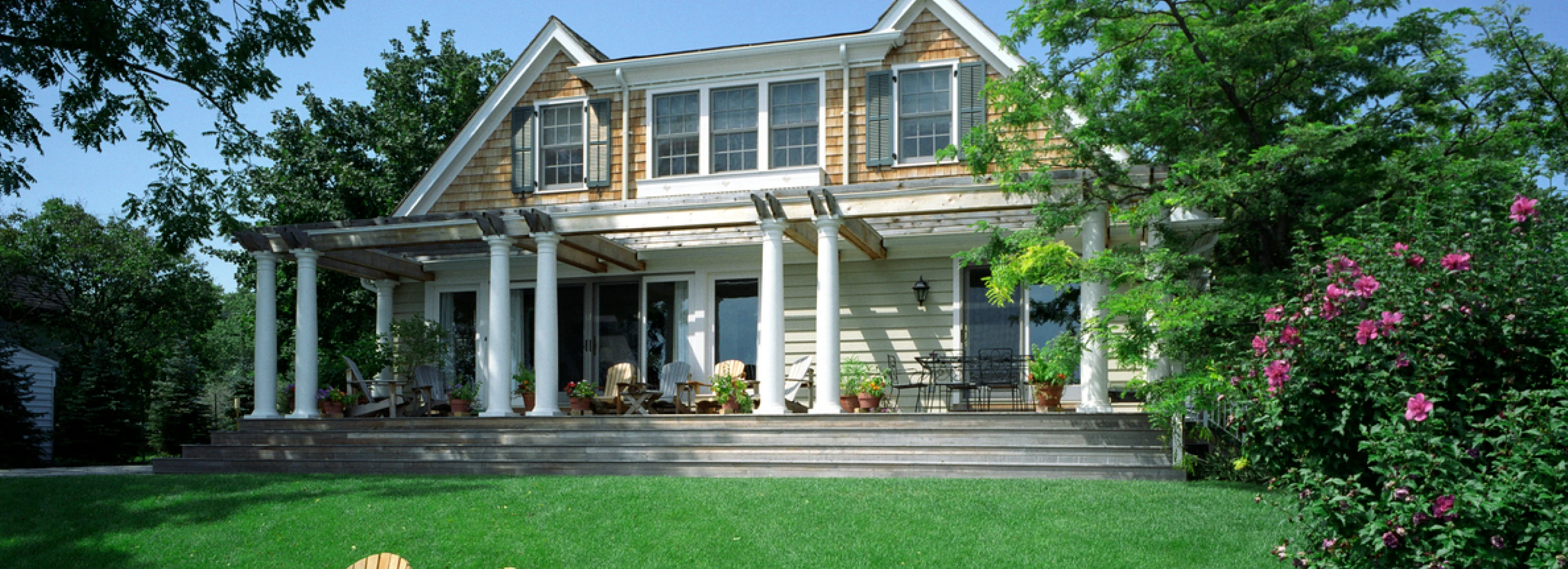 Front of a beautiful home with a lush, green lawn in front of it