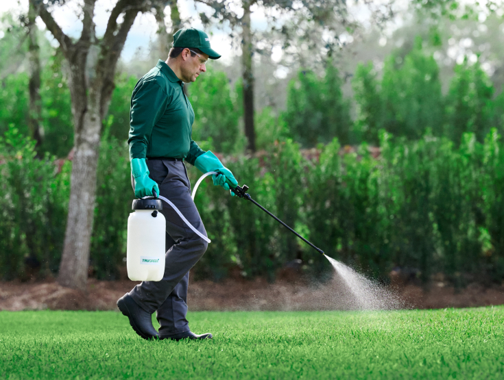 TruGreen specialist treating a lawn to control clover