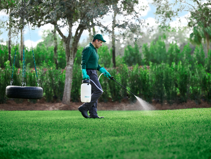 TruGreen specialist treating a lawn for weeds