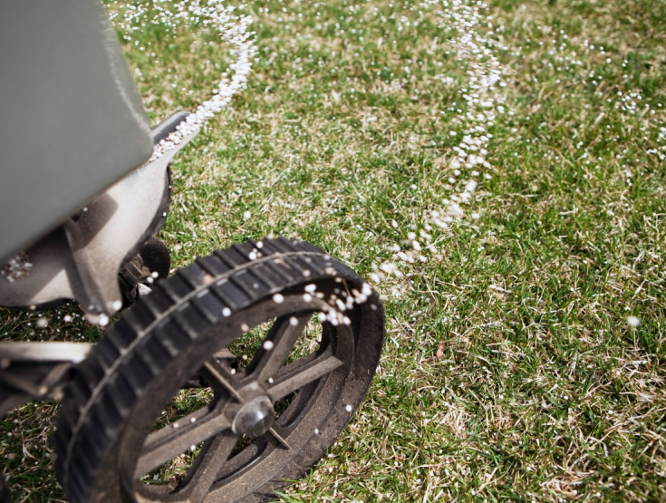 Close-up of a spreader spreading fertilizer